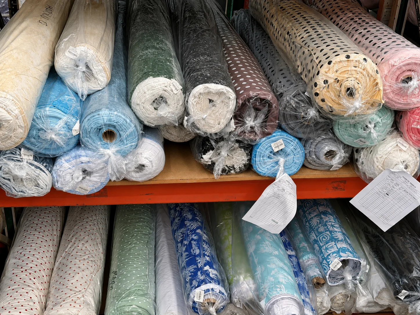 Variedad de rollos textiles lisos y estampados en JJTEX